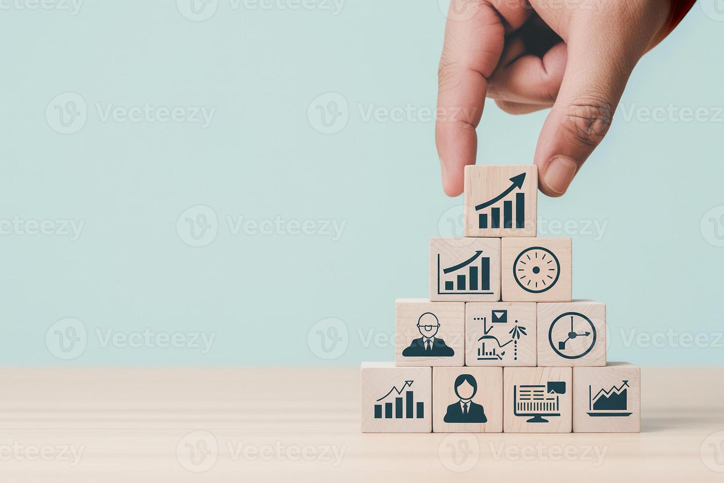 Hand placing wooden block with growth chart icon on top of a pyramid structure symbolizing business success and strategic planning The concept of building a successful team and achieving goals through photo