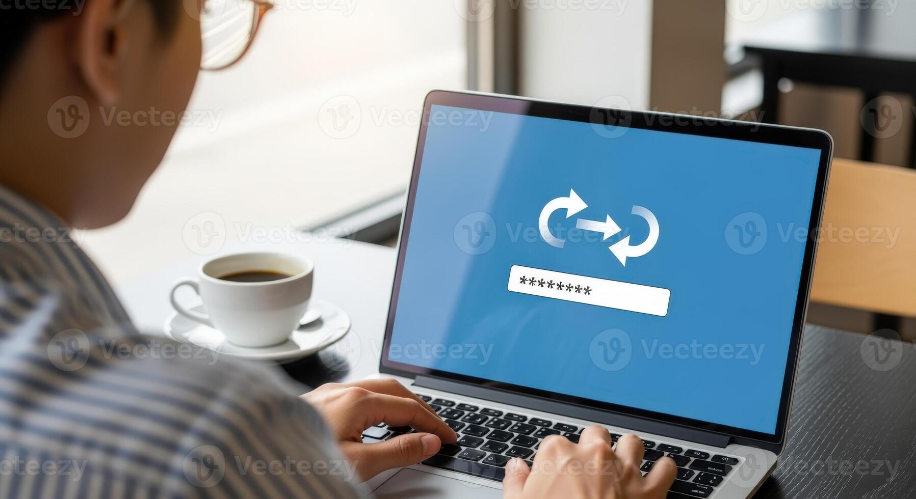 Man Typing on Laptop Showing Password Reset Screen with Coffee in Cafe Setting photo