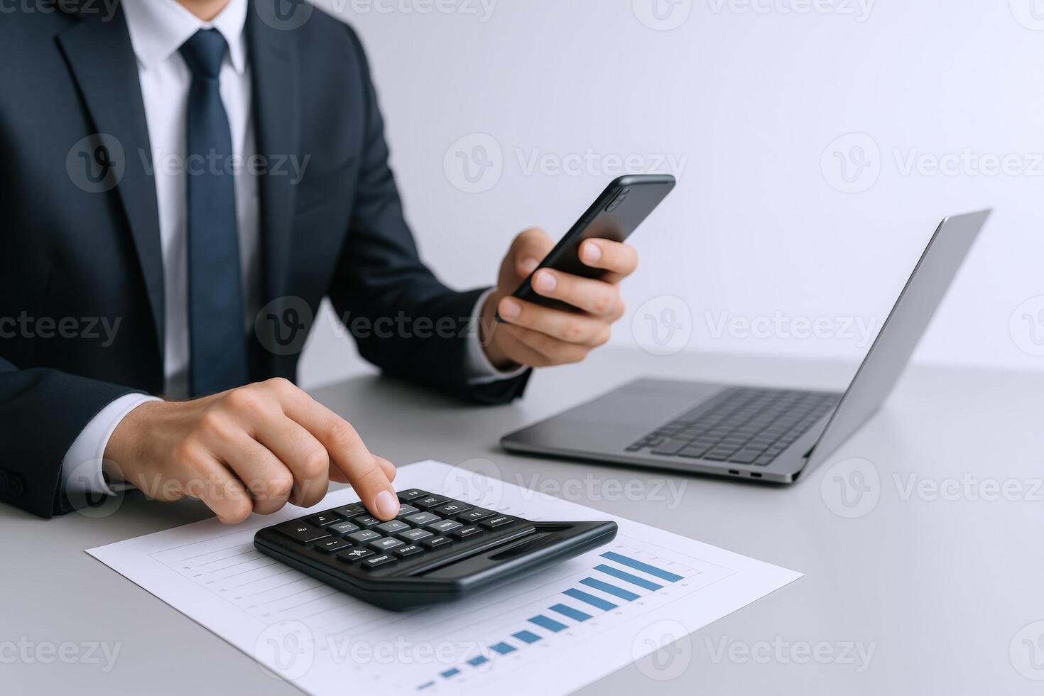 Financial Analyst Calculating Data Using a Calculator and Mobile Phone in an Office Setting photo
