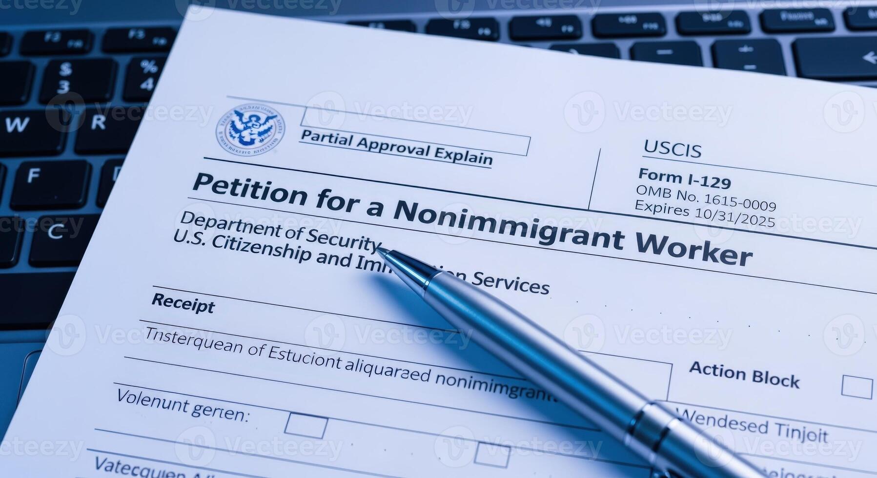 I-129 Petition for a Nonimmigrant Worker application form close up with a pen and part of keyboard photo