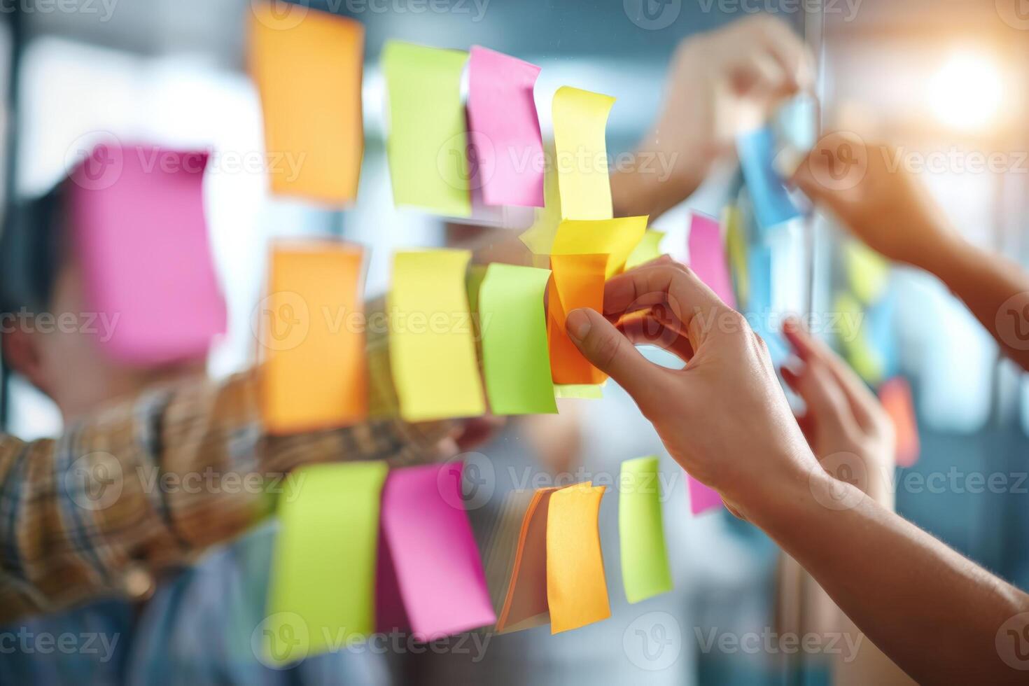 Brainstorming Session Team Collaborating with Sticky Notes on Glass Wall for Project Planning and Agile Workflow photo