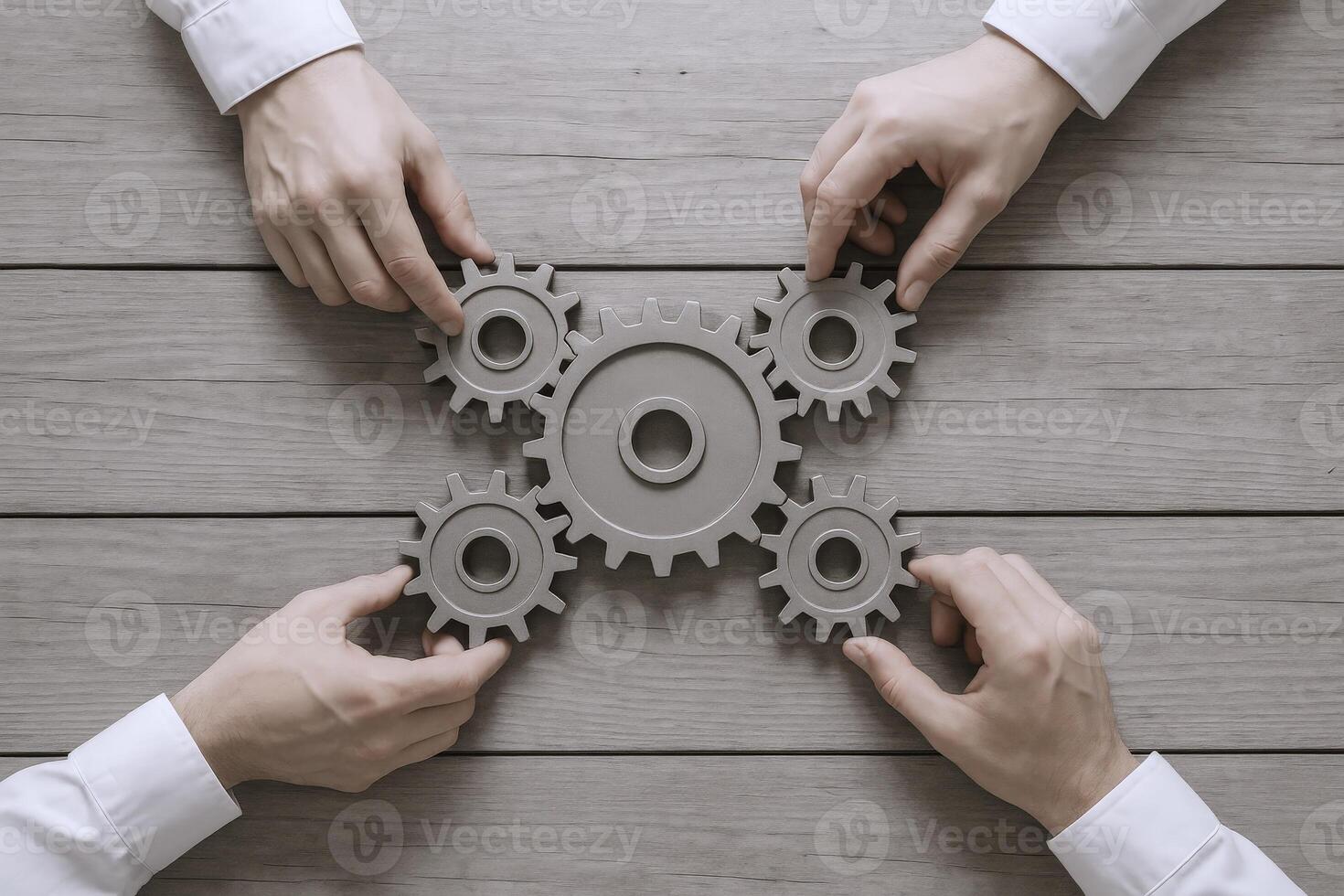 Teamwork Concept Four Hands Connecting Gears on a Wooden Surface - Collaboration and Solutions photo