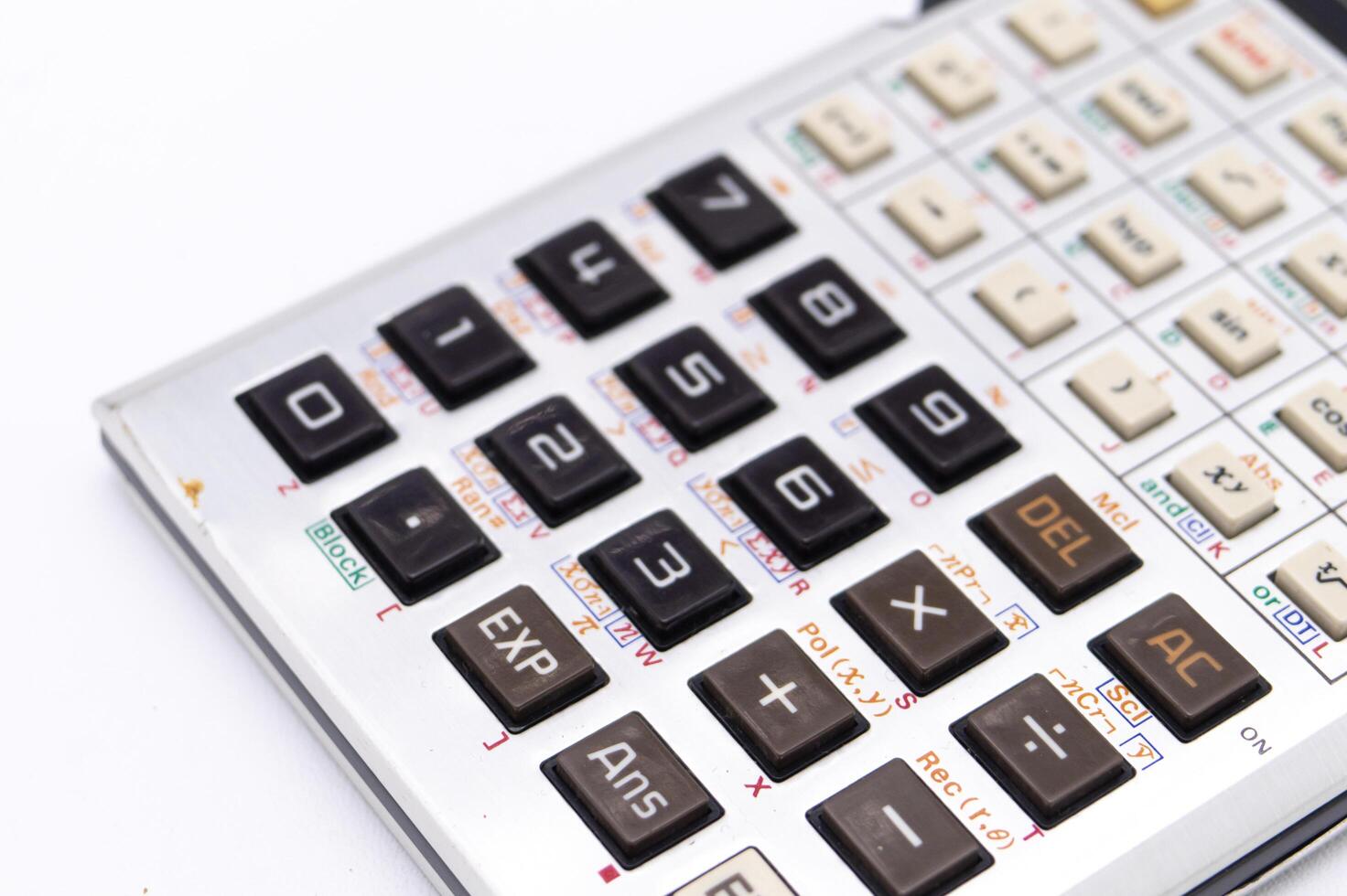 Close-up of a Silver Calculator with Black Buttons on a White Background Showing Numbers and Functions. photo