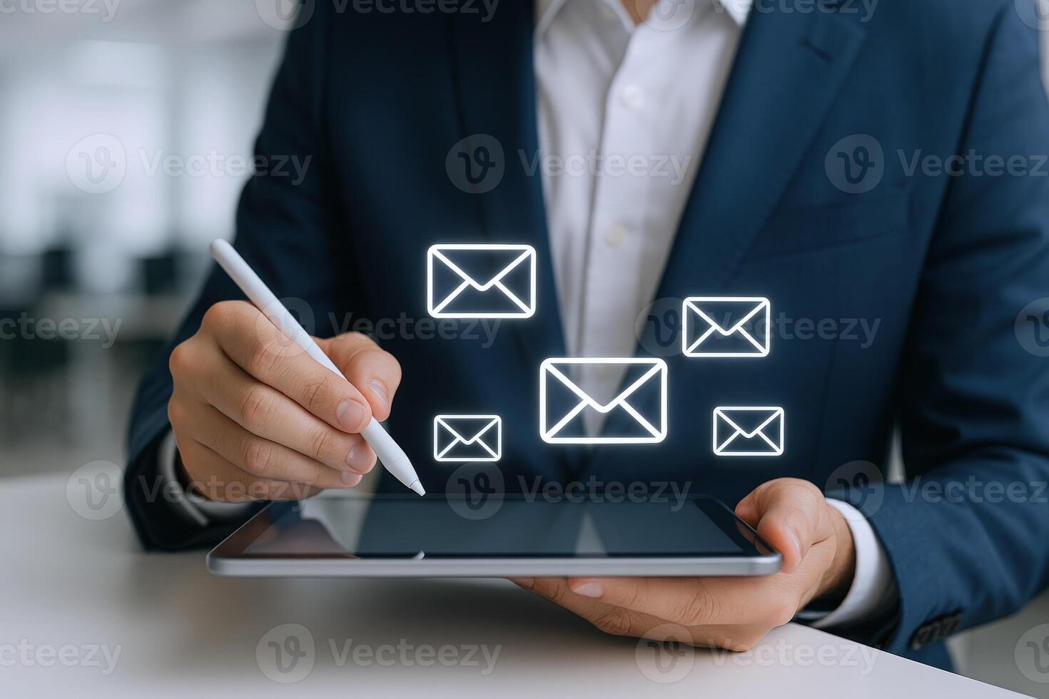 Businessman using digital tablet with email icons hovering above, concept for communication and marketing solutions photo