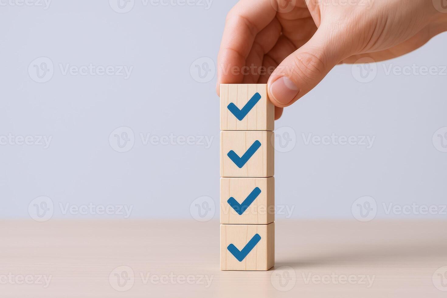 Hand Stacking Wooden Blocks with Checkmarks Representing Completed Tasks, Goals Achieved, and a Successful Workflow photo