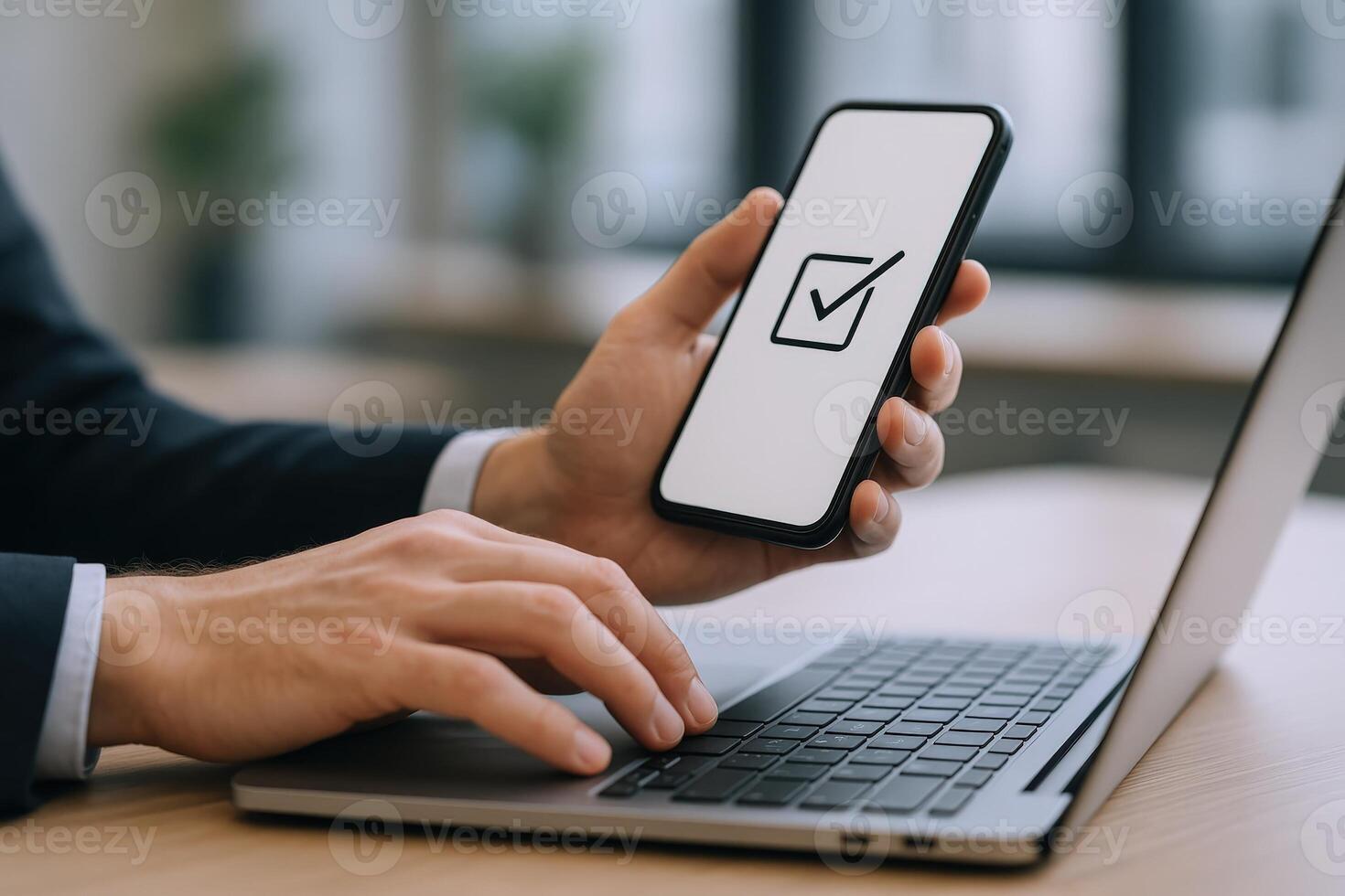 Man Completes Digital Task on Smartphone While Typing on Laptop Keyboard for Enhanced Productivity photo