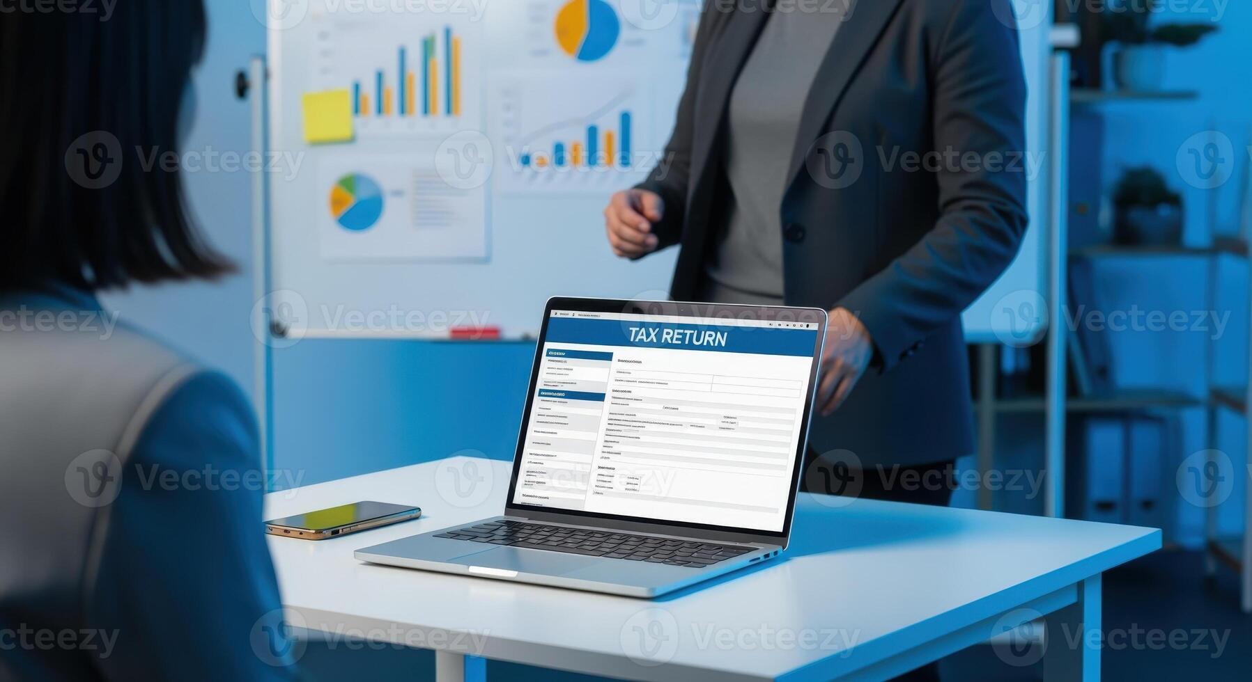 Business Meeting for Tax Return Presentation with Charts and Laptop Displaying Online Form in Office Setting photo
