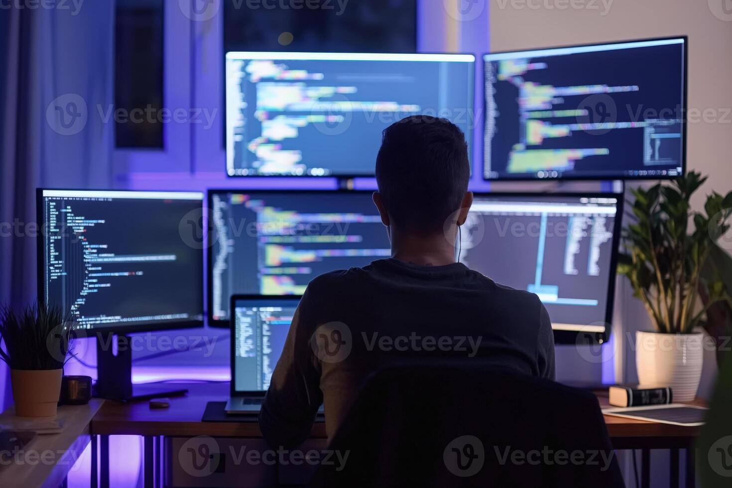 Software developer working late night programming and coding on multiple monitors photo