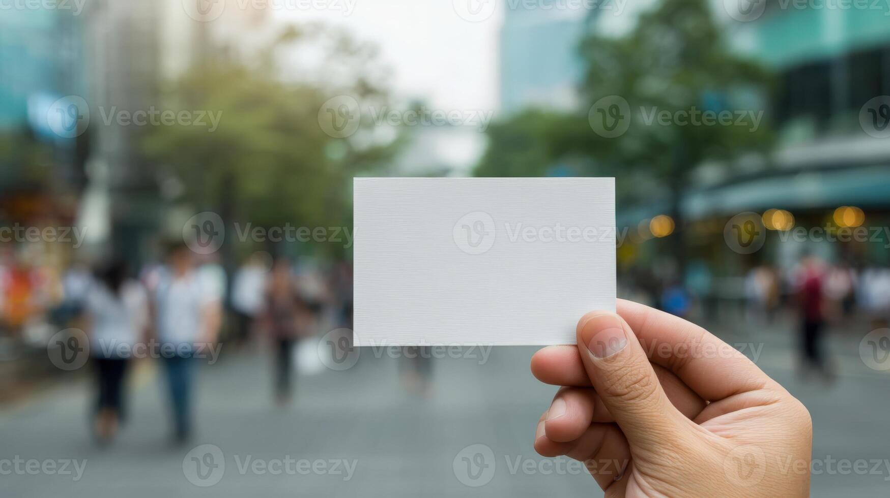 Hand Holding Blank Business Card in Urban Setting for Mockup Design and Promotion photo