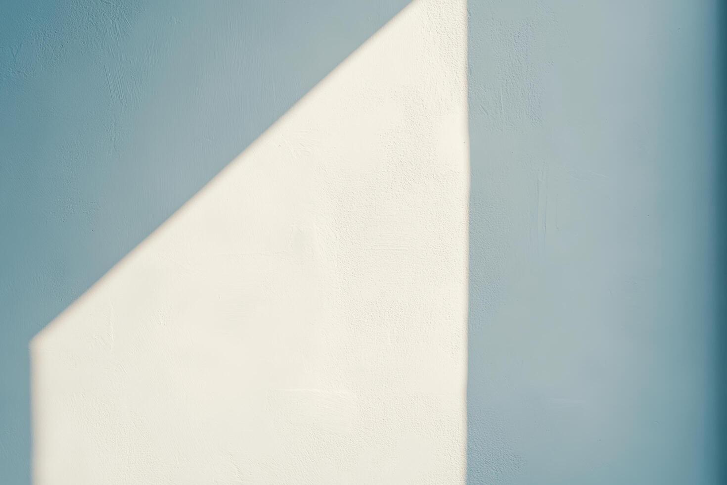 Light and shadow create a geometric pattern on a textured wall photo