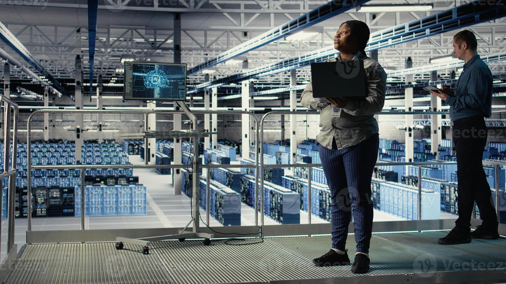 Data center supervisor on industrial platform working to improve AI rigs processing speed. African american server hub manager overseeing gear supporting artificial intelligence workloads, camera A photo