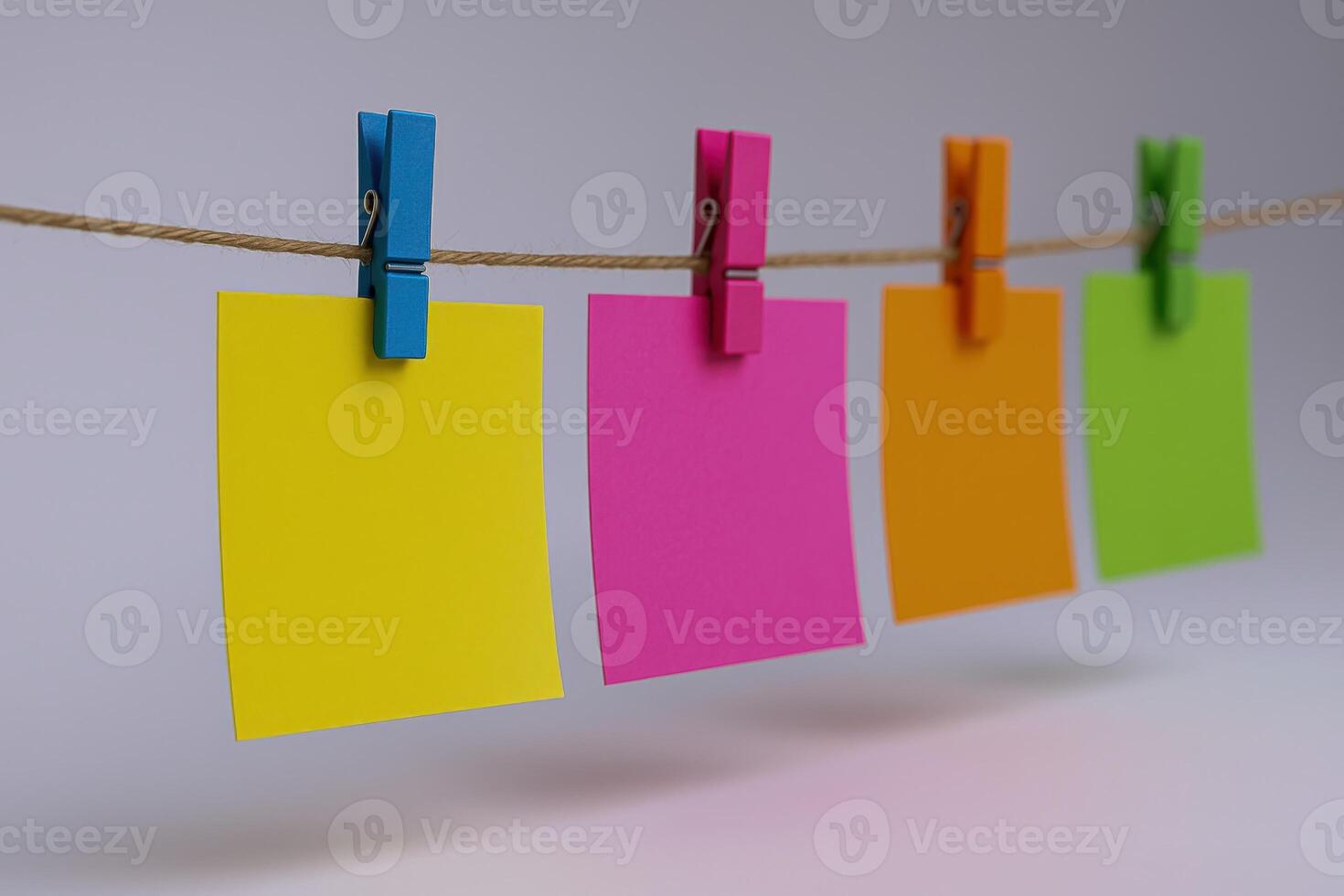 Colorful Sticky Notes Hanging on a Twine String with Clothespins Against a White Background photo