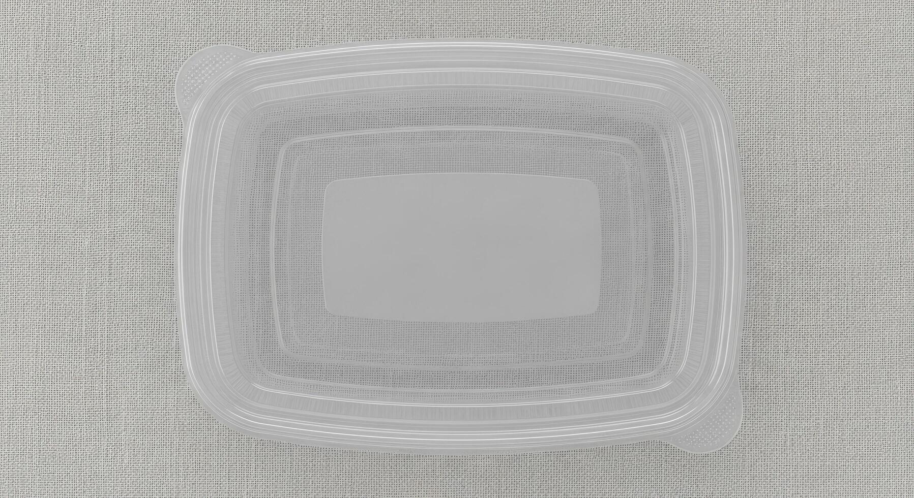 Clear plastic rectangular food container with a translucent lid, top view on a neutral textured background photo