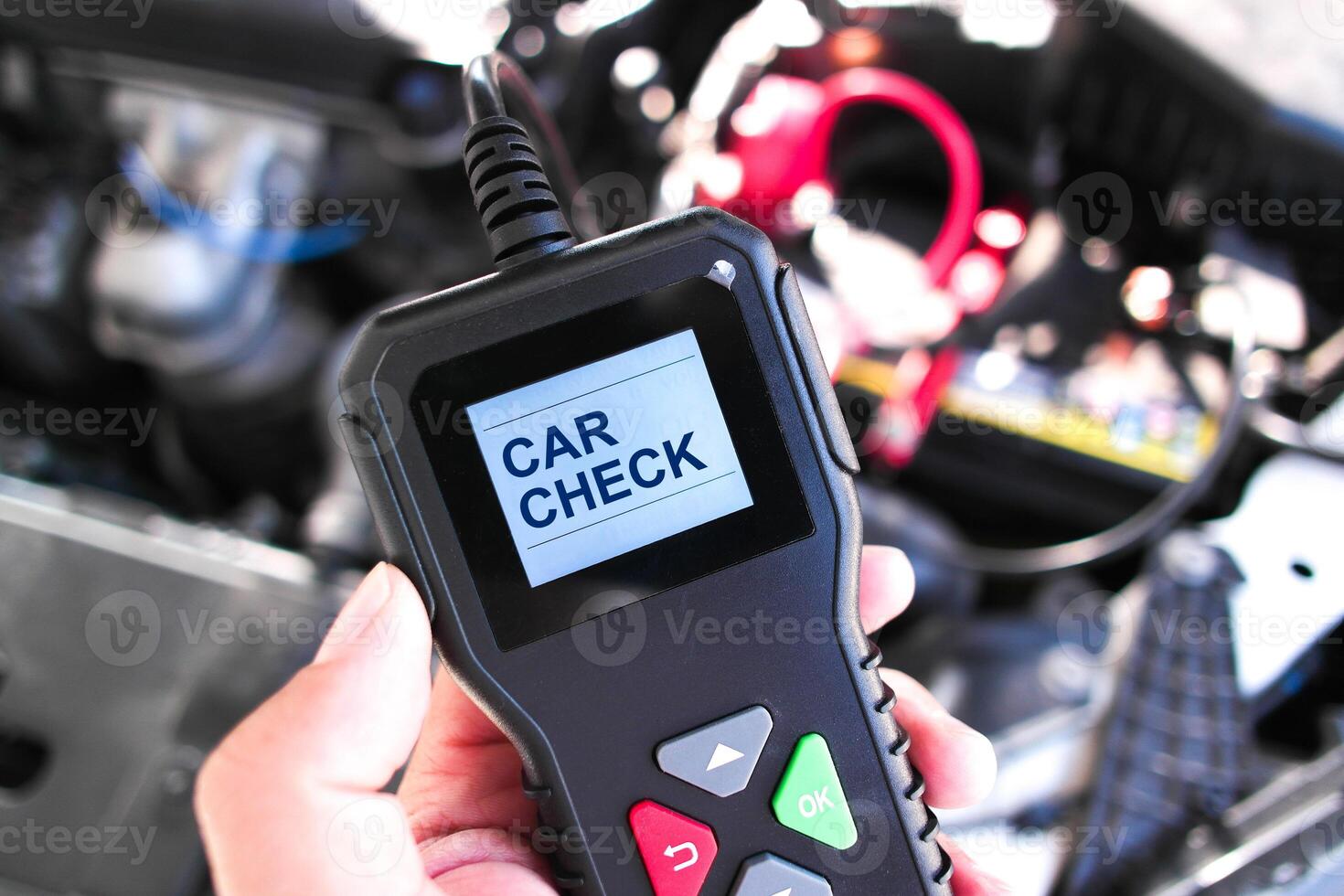Hand holding an OBD2 car diagnostic scanner with screen displaying Car Check, used for vehicle maintenance, engine error code reading, and automotive troubleshooting photo