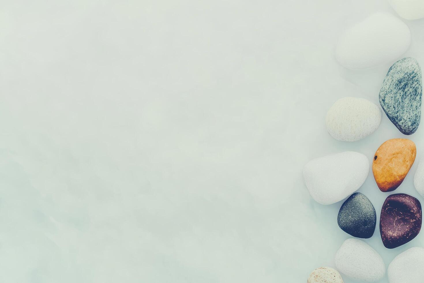 Colorful pebbles arranged on a light surface in a serene setting photo
