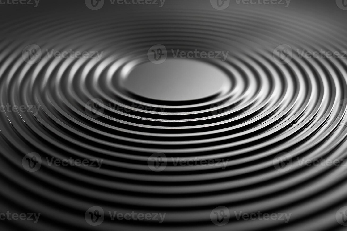 Circular grooves on a black surface create a reflective pattern photo