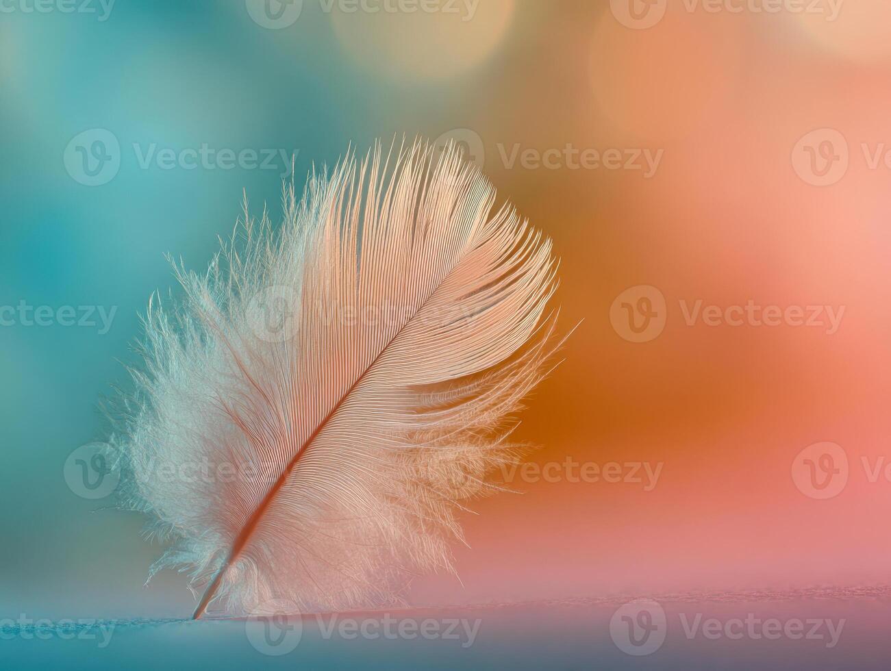 Soft delicate feather standing upright on smooth surface with a dreamy pastel-colored blurred background creating a serene and airy atmosphere photo