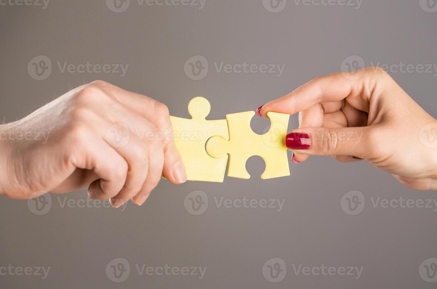 Hands connecting puzzle. Puzzles. Hand of the child and hand of mother fold puzzle, closeup. Hands hold puzzles. Solution of problems. Mens and childs hands connecting puzzles photo