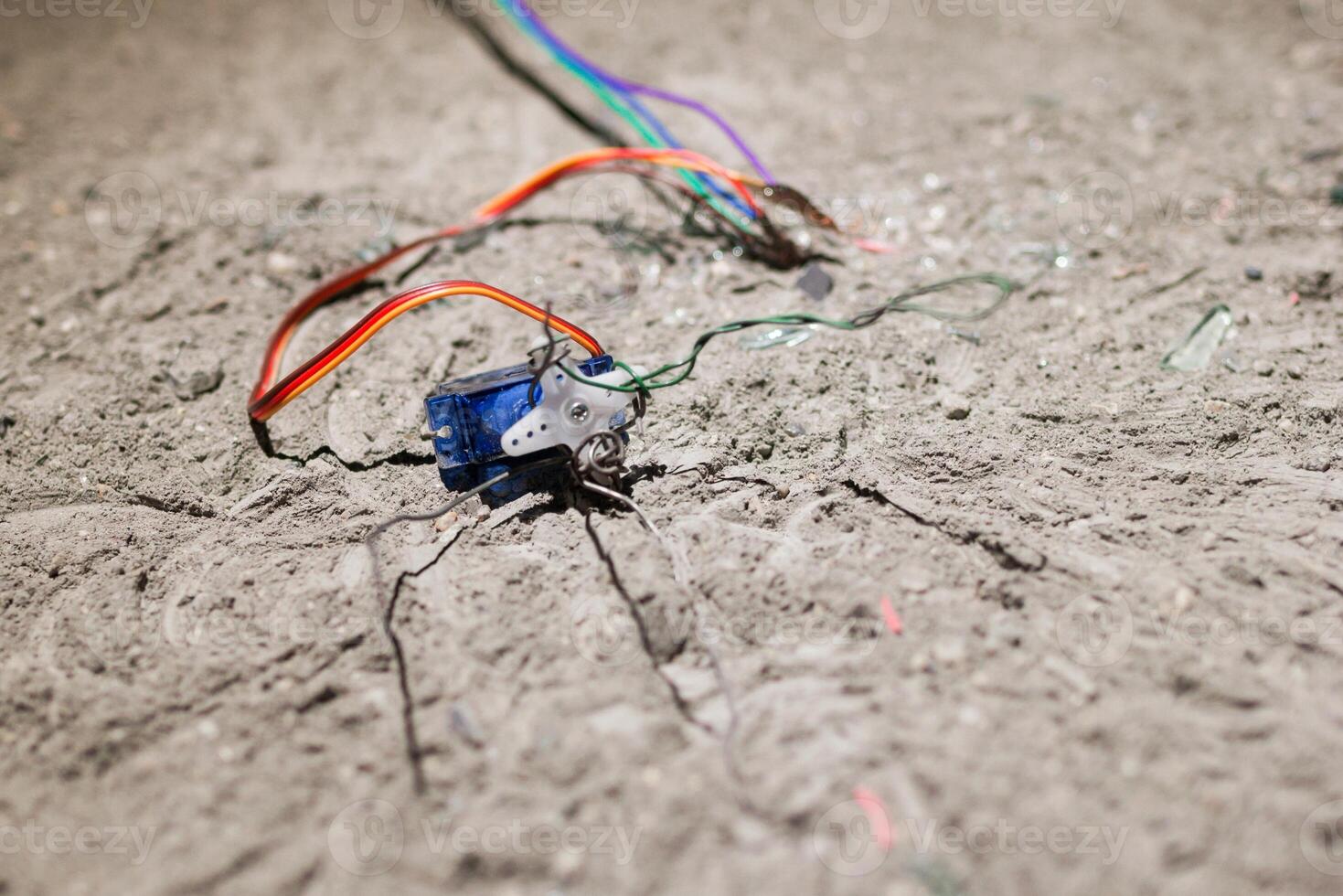 Electronic Component Surrounded by Wires on Rough Concrete Surface, Close-Up View, Technical Concept photo