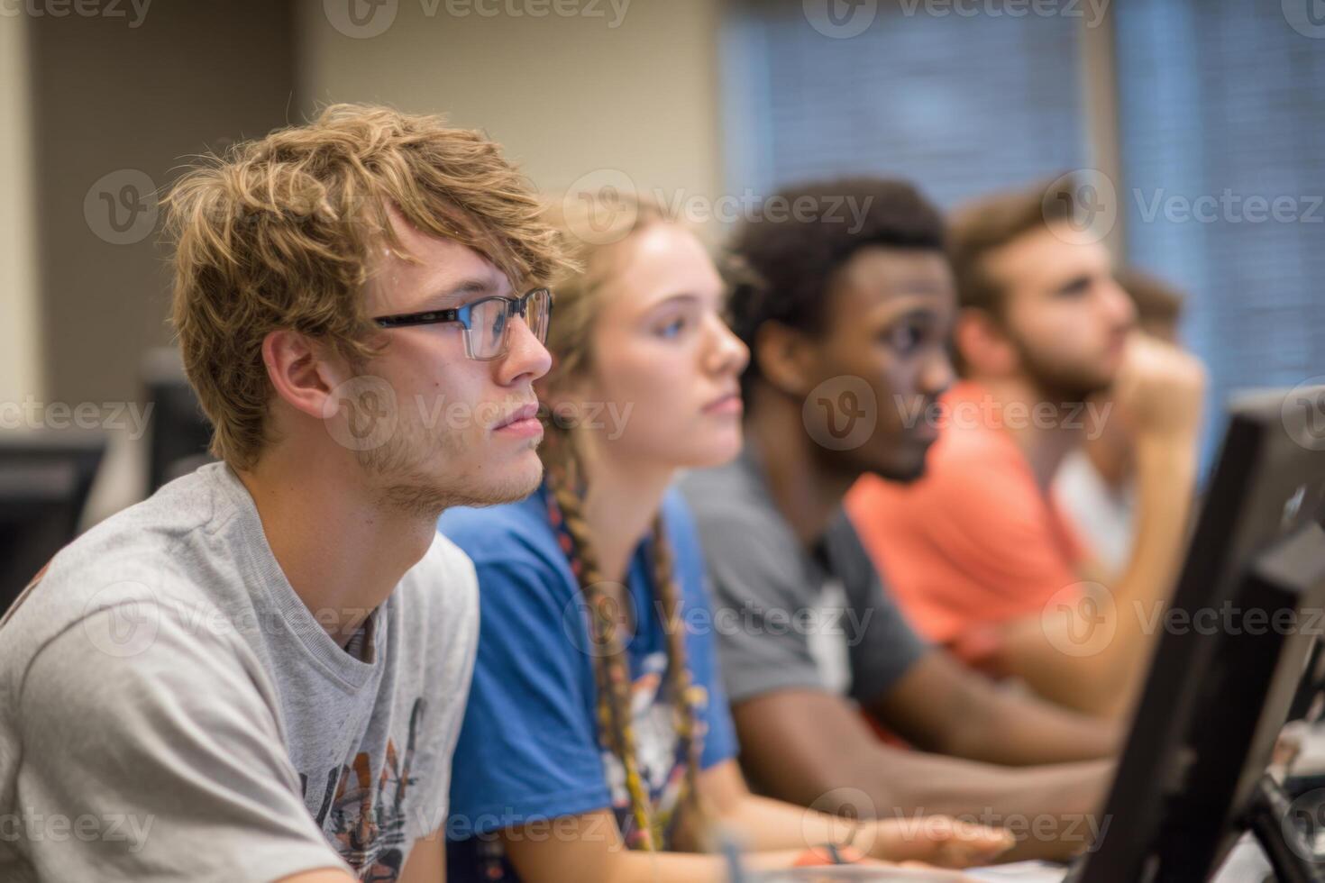 A group of students focused on their computer screens during a coding class at a university. The setting highlights concentration and collaboration among peers learning new skills photo