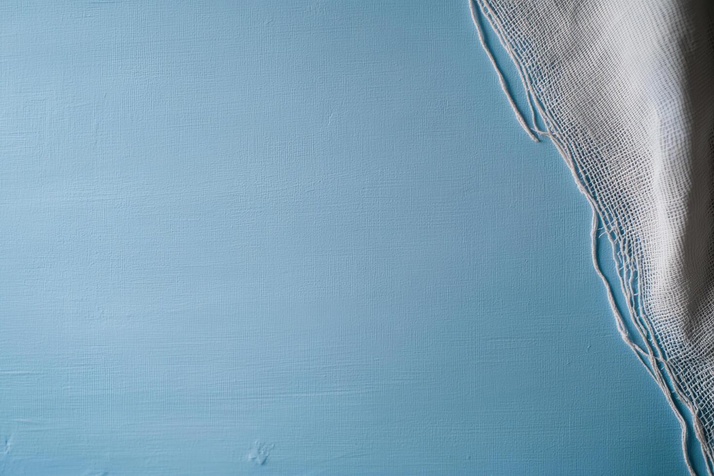 Blue textured surface with a white fabric edge creating a minimal design photo