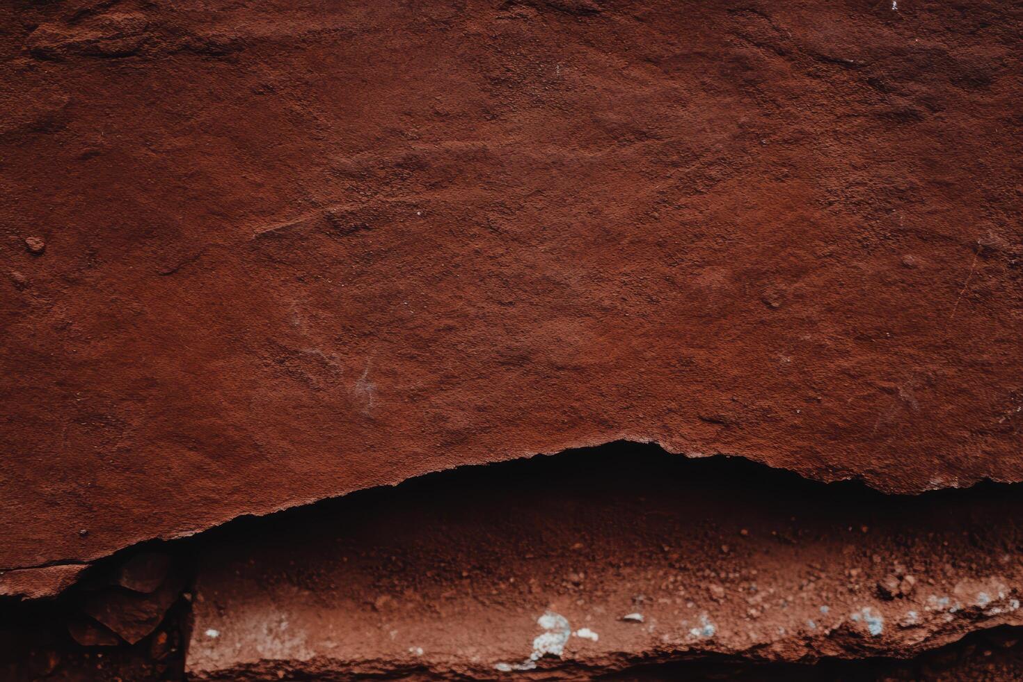 Textured red rock surface with subtle variations in shade and pattern photo