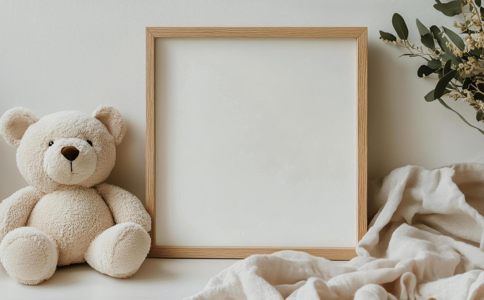 Blank Square Frame on a White Surface With a Teddy Bear and Soft Cloth photo
