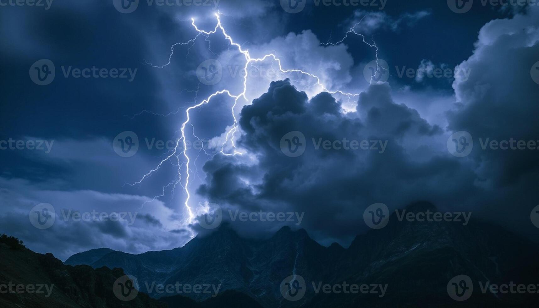Lightning strikes over a mountain range with clouds in the background photo