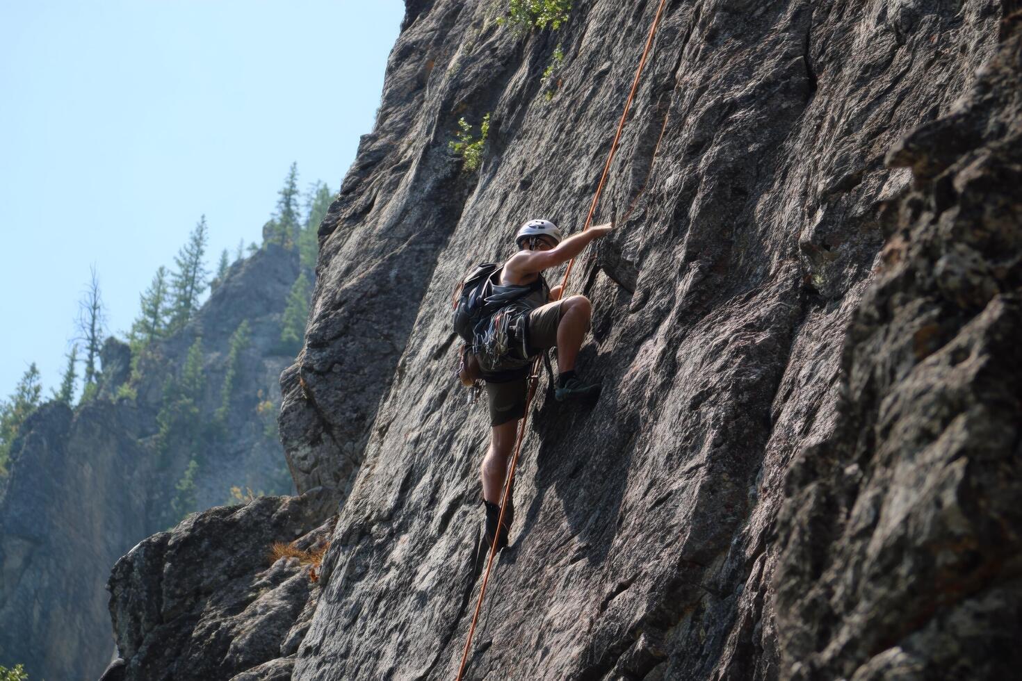A man climbing up a rock face photo