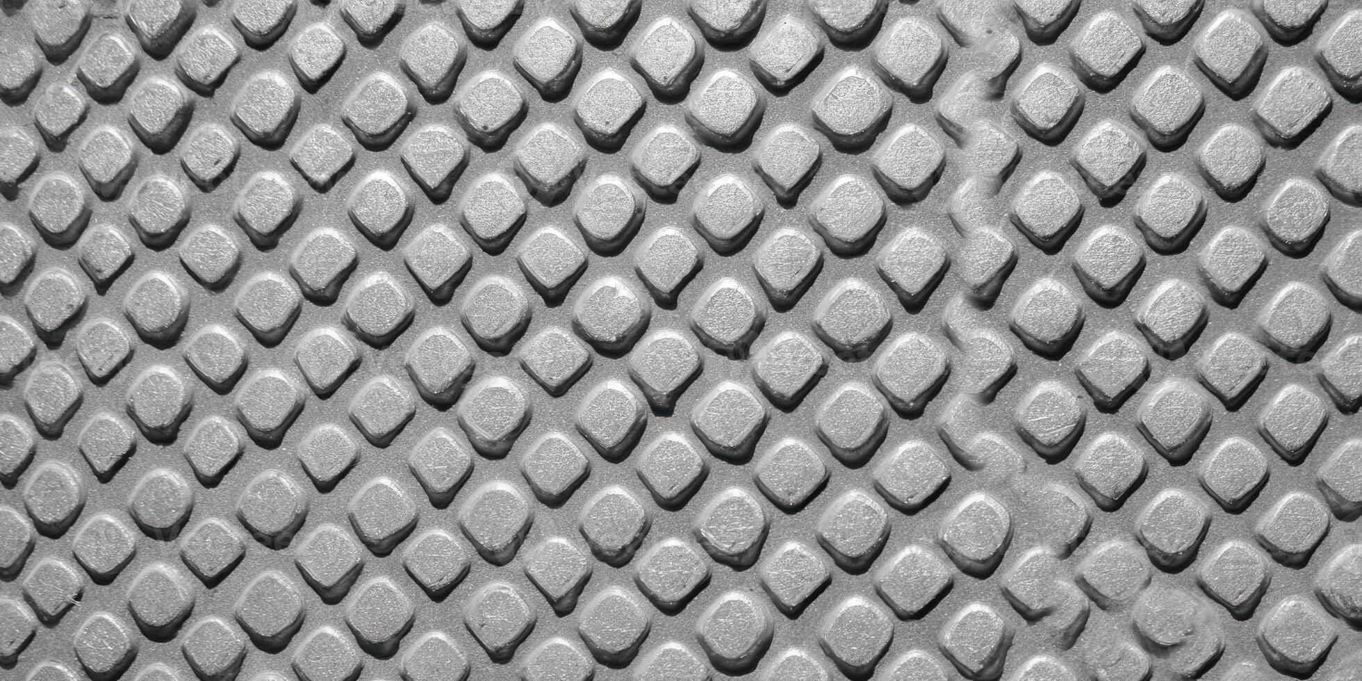 The intricate texture of a metal surface with a diamond pattern is highlighted. photo