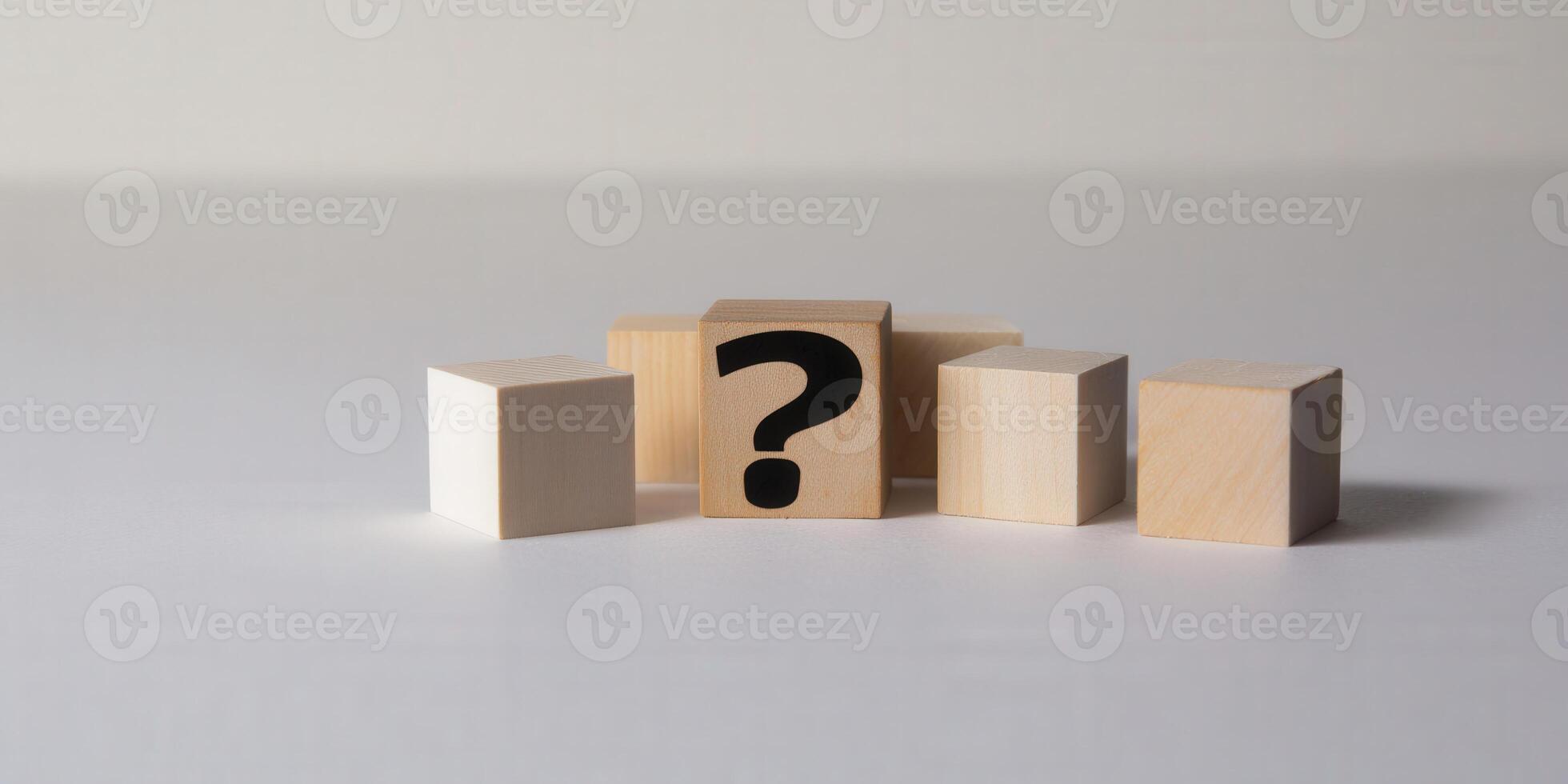 A wooden block with a black question mark is the main focus of the image. photo