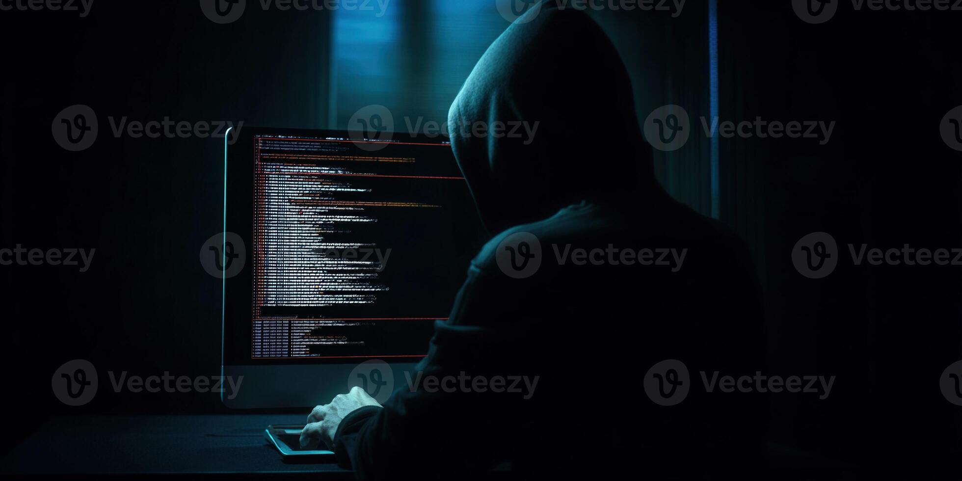 A mysterious hacker works on a computer, possibly stealing or hiding data in the shadows. photo