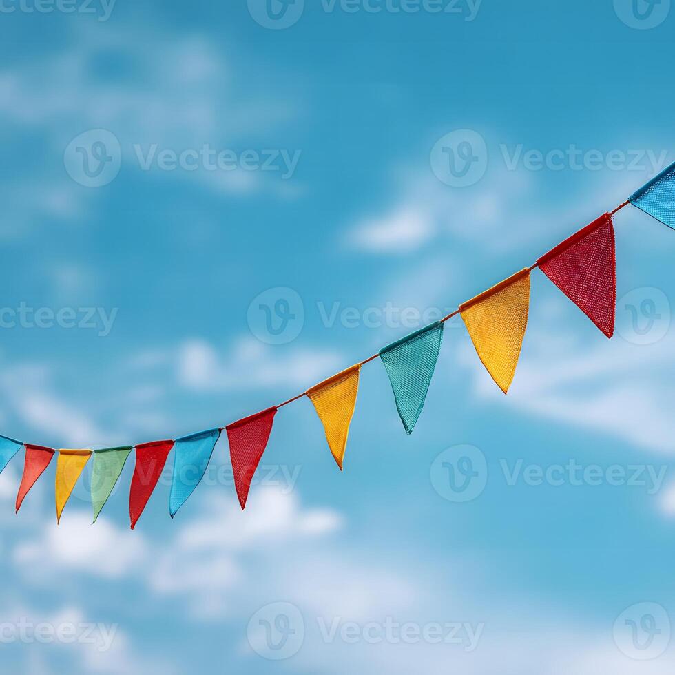 Diagonal string of multicolored bunting flags against a blue sky with wispy clouds photo
