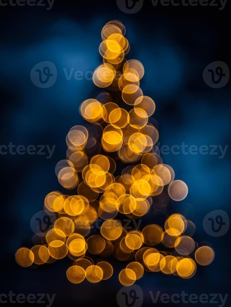 Soft glowing golden lights arranged in a triangular pattern resembling a festive holiday tree against a deep blue and black blurred background at night photo