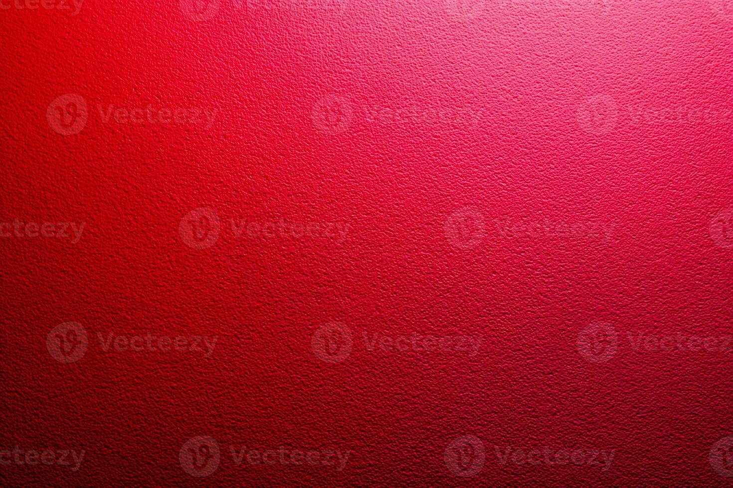 Close-up of vivid red textured wall surface with subtle light gradient creating a vibrant and dynamic background for creative design or artistic projects photo