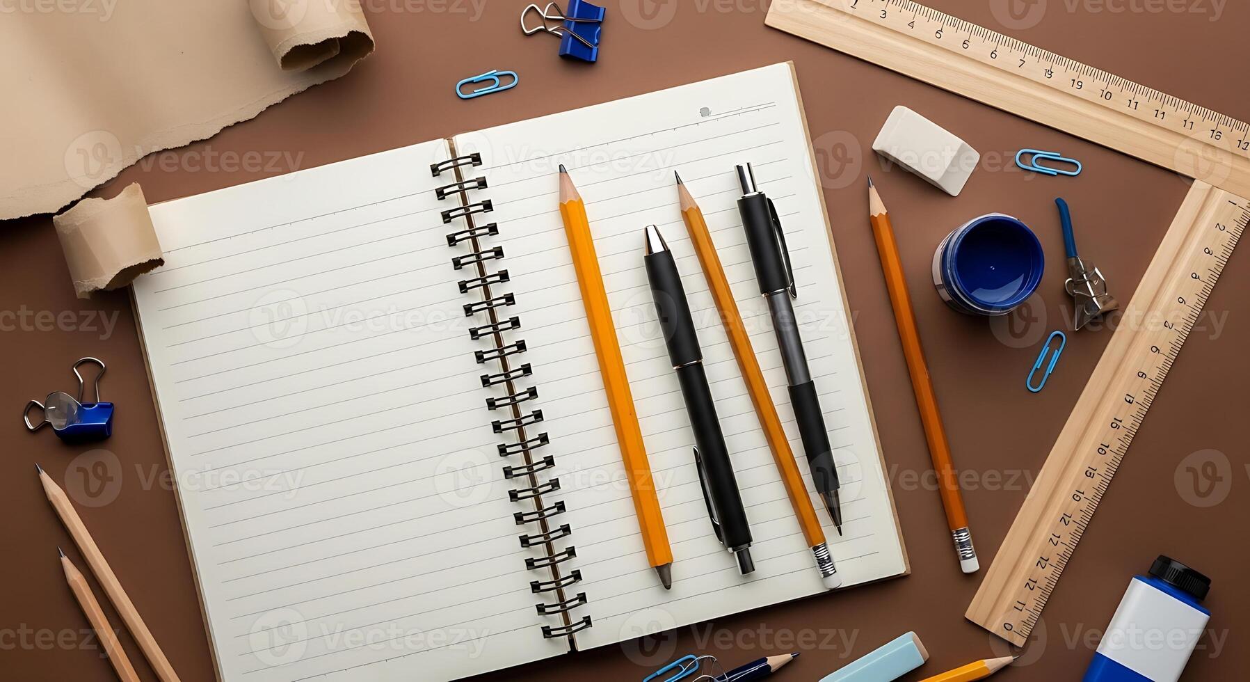 Workspace Flat Lay Open Notebook Pencils Rulers and Paper Scroll on Brown Background for Creative Design Projects photo