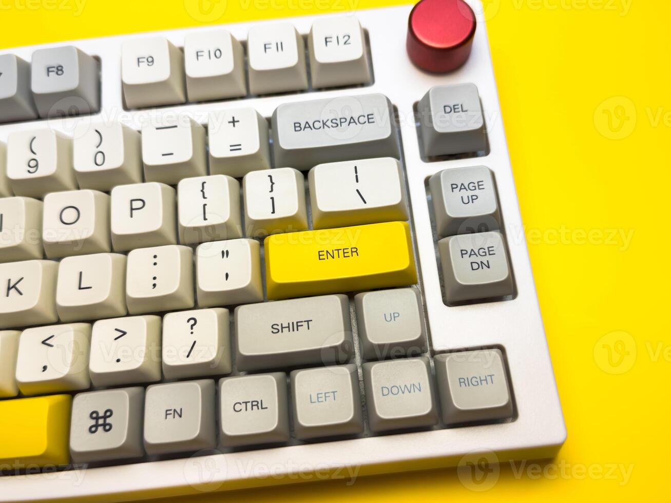 White office keyboard with bright Enter key on bright yellow background, minimalism, keyboard buttons. A keyboard with a yellow key on the bottom left photo