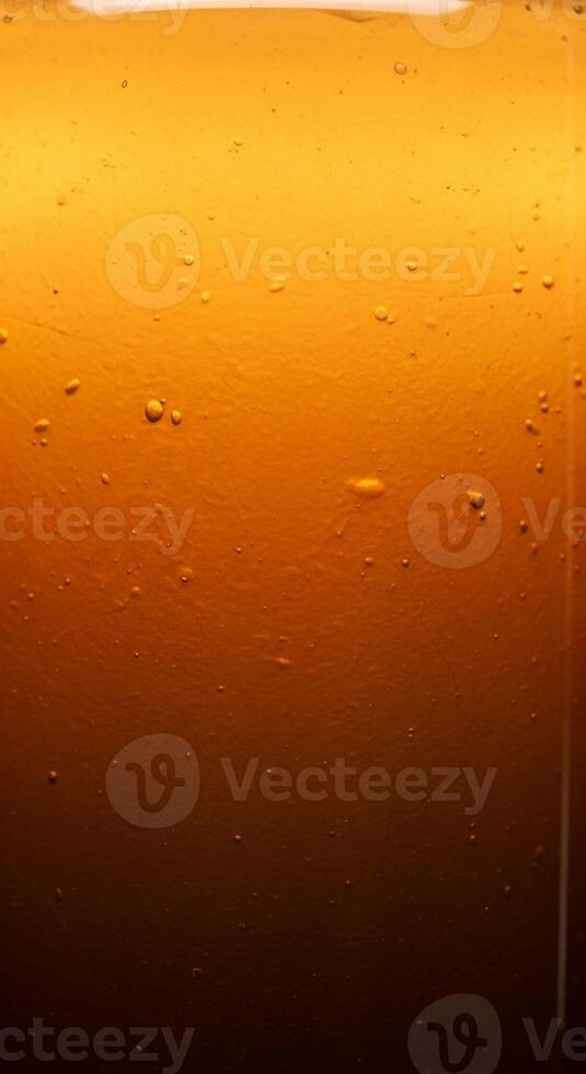 Close up macro shot of refreshing amber colored liquid with tiny bubbles and a gradient effect photo