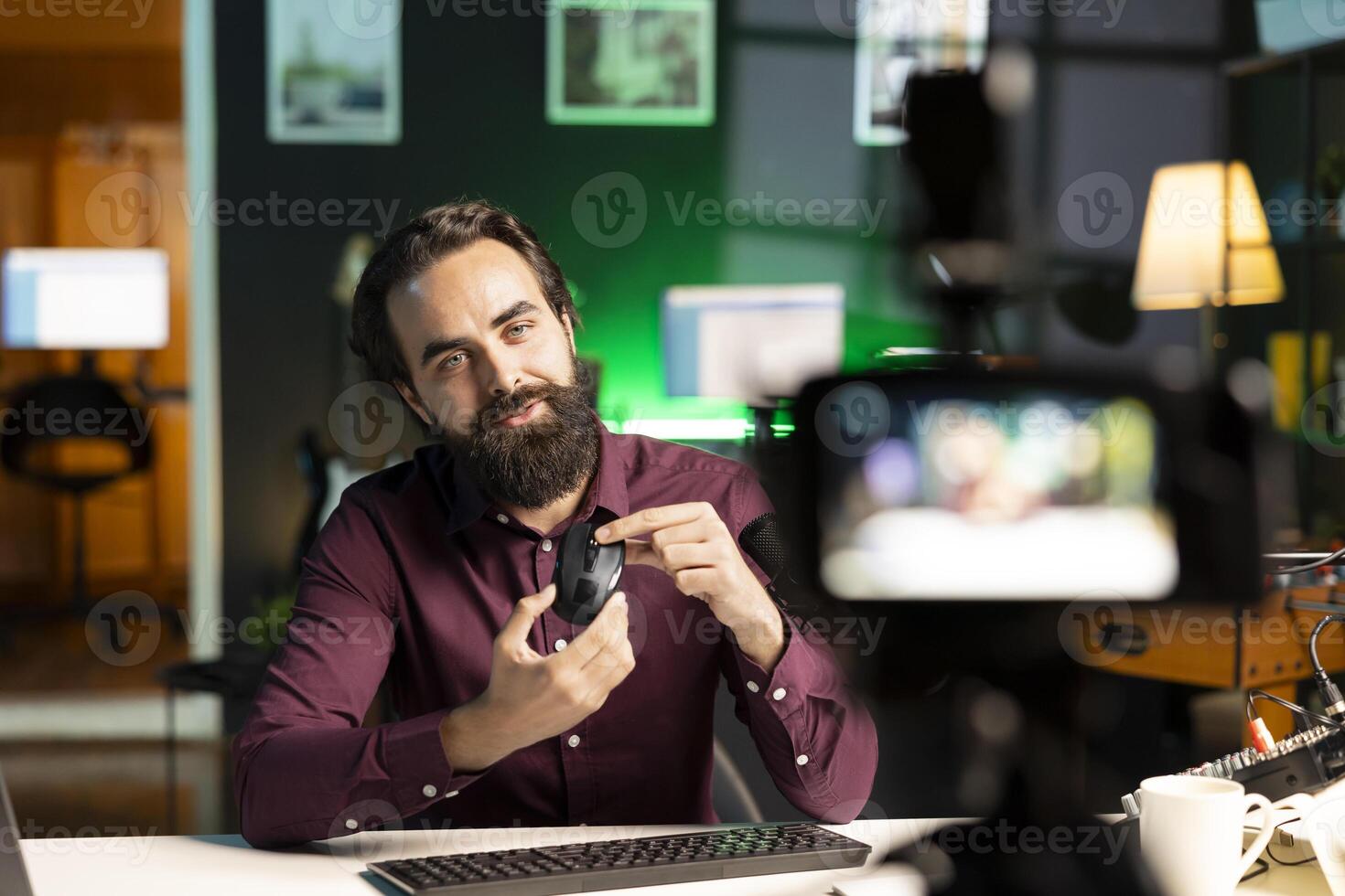Tech guru filming technology review of office mouse for audience using professional camera. Content creator assessing computer peripheral device, recording with specialized equipment photo