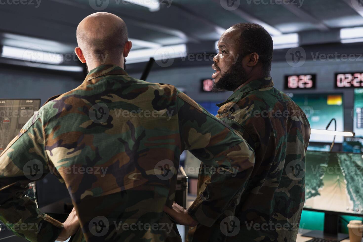 Military officer and colleague operating high tech aerial systems to support reconnaissance and target identification. Team of army specialists monitoring counterinsurgency attacks photo