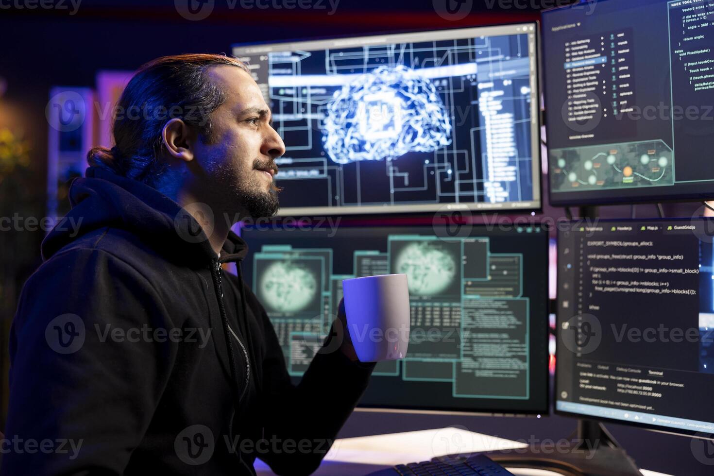 Smiling cybercriminal holding coffee mug coding on PC, trying to evade security with stealth malware. Evil man drinking beverage uses script hiding malicious code from detection systems photo