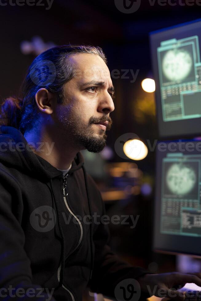 Hacker frowning after being unable to do phishing attacks and trick users into revealing credit card data. Man annoyed after DDoS attacks fail to flood servers and crash websites photo