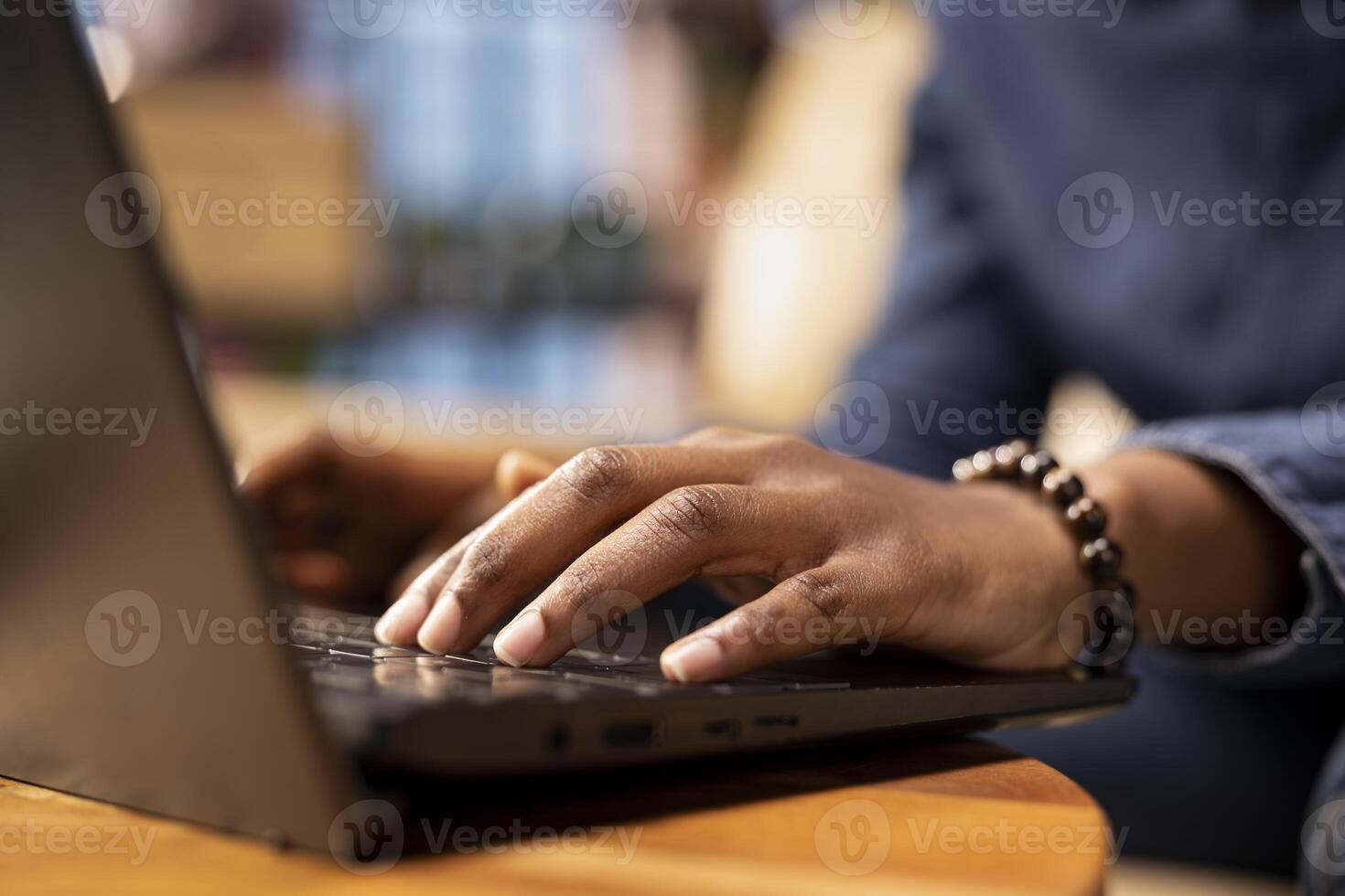 Person at home browsing internet on laptop and researching information online, accessing websites and reading articles while she sits on the couch. Find data relevant to work tasks. Close up. photo