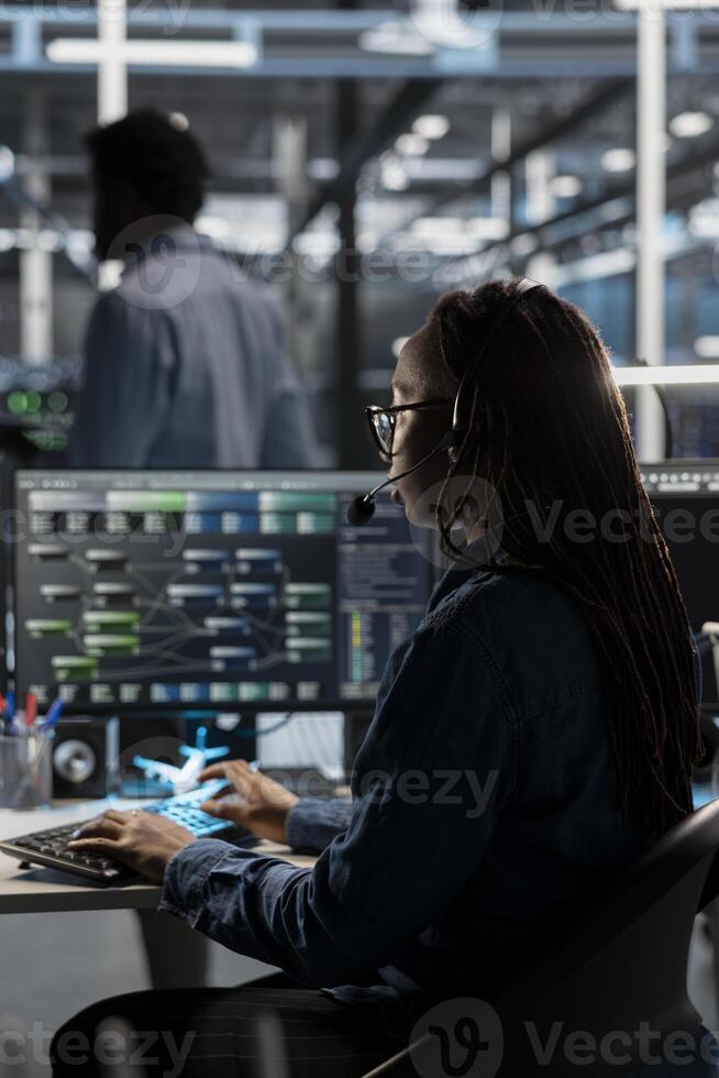IT specialist in data center looking at node trees, providing technical support to customers. Server room worker carrying out operational technical interventions requested by clients photo