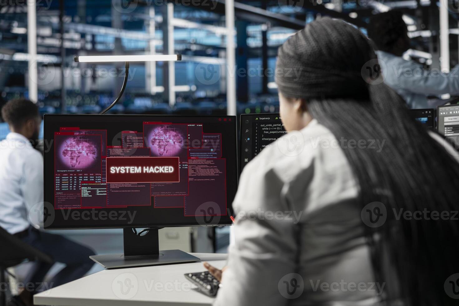 System administrator in server room seeing warning on PC alerting of sensitive data threatened by hacking attack. Woman afraid of cyberattack, struggling to save data center from unauthorized access photo