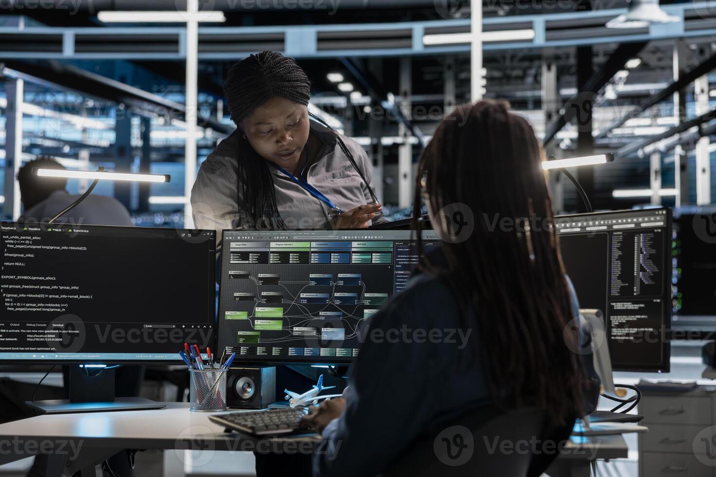 Data center manager supervising engineer setting up machine learning systems handling information. Supervisor oversees worker training node trees neural networks to improve server hub operations photo