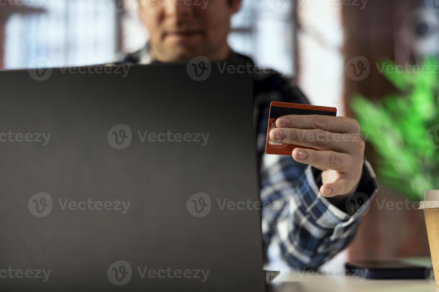 Man doing internet shopping, typing credit card information on notebook, placing products in cart. Close up of buyer doing online transactions, adding payment method on website photo