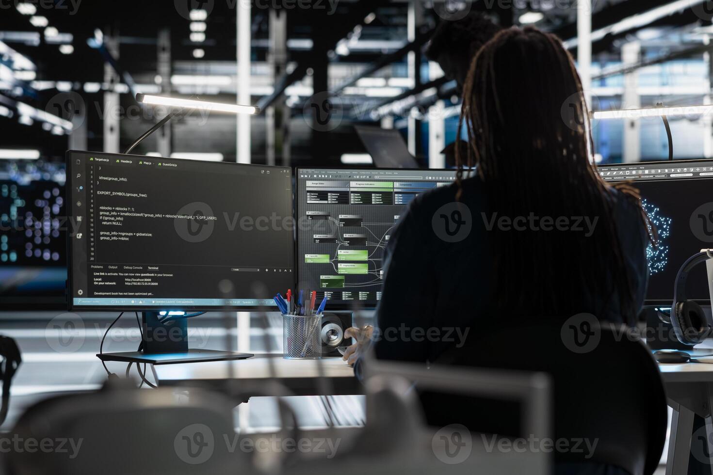 Server room programmer coding, using artificial intelligence to enhance operational efficiency and reduce downtime. Worker designs and implements AI driven solutions for data center equipment using PC photo