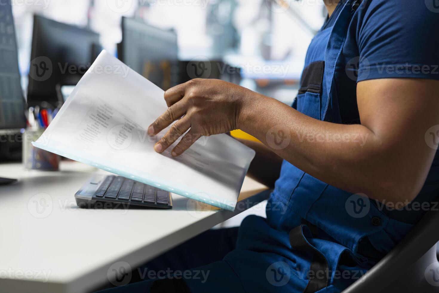 Solar panel engineer reviews system designs on computer setup, using high tech manufacturing equipment and user manual at the power plant. Man works on optimizing photovoltaic technology. photo
