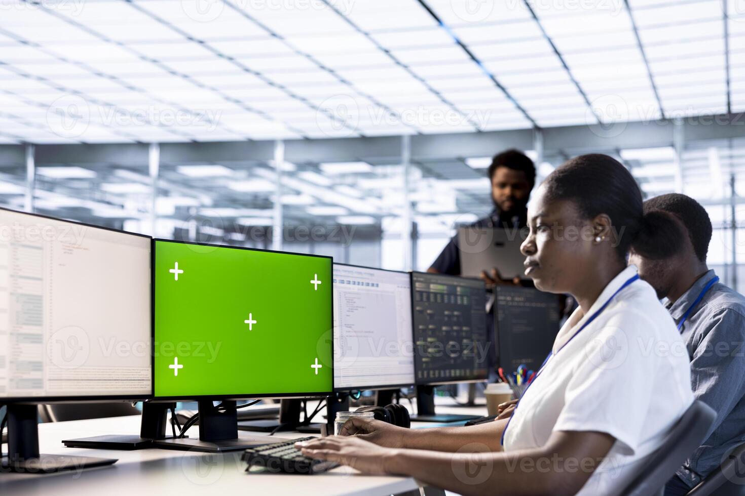 Server room technician using green screen computer to find firewall misconfigurations. Woman checking systems bottlenecks leading to sluggish data transfer rates using chroma key PC photo